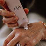 Person applicerar CANA CARE Soft handcreme på handryggen.