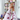 Ett par fötter är upplyfta framför en bokhylla, där små smileys är målade med kräm på tårna. Personen har rosa Hello Kitty-byxor på sig och sitter avslappnad hemma.