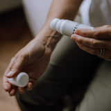 En person applicerar “Breeze” roll-on från Cana Care på handleden – en kylande booster med lugnande effekt.