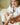 Litet barn sitter på sängen och ler medan en vuxen räcker fram en vit flaska med texten “REST” mot henne.